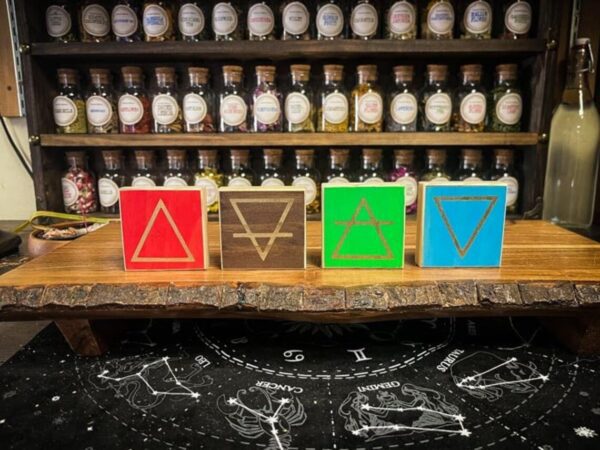 A table with four different colored bottles on it.