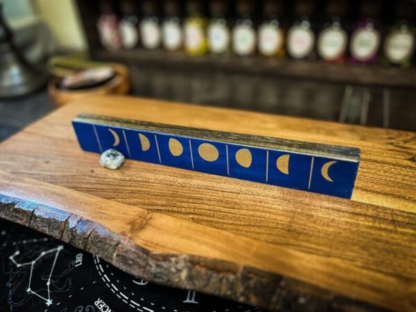 A wooden table with a blue tile piece of art on it.