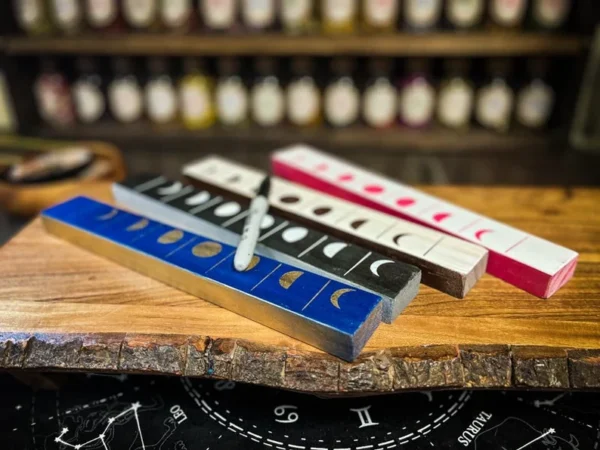 A wooden table with four different colored rulers.