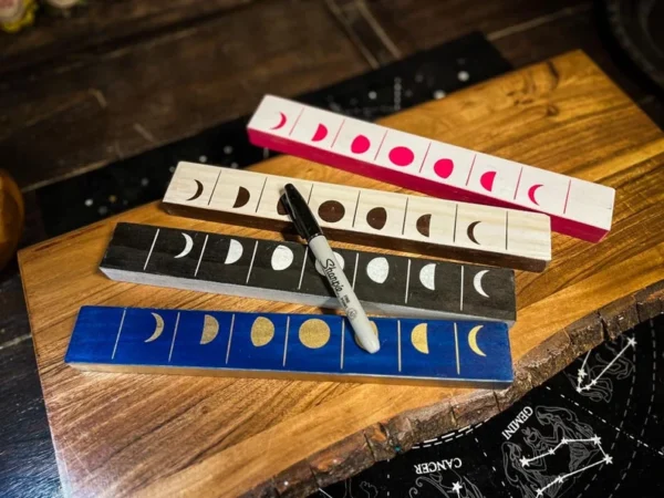 A wooden table with four different colored rulers.