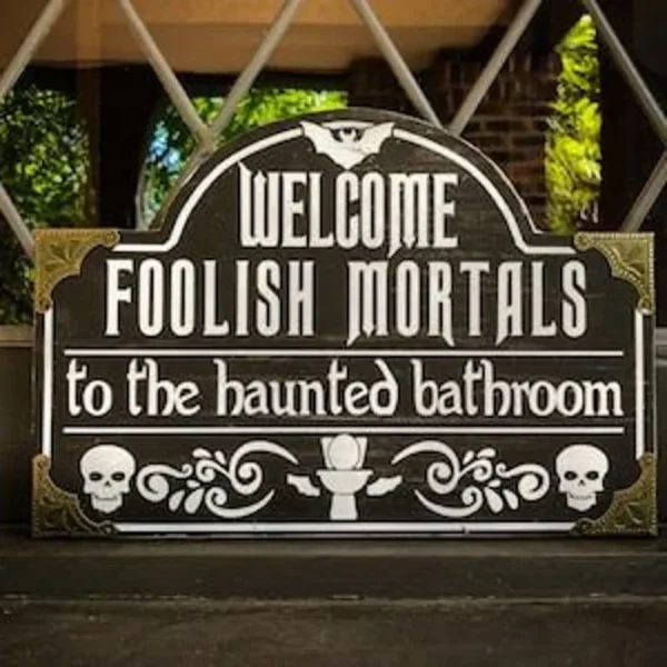 A sign that says welcome foolish mortals to the haunted bathroom.