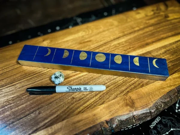 A wooden table with some writing instruments on it