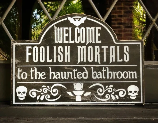 A sign that says welcome foolish mortals to the haunted bathroom.