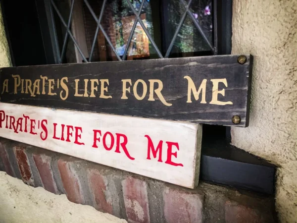 A couple of wooden signs that are on the side of a building.