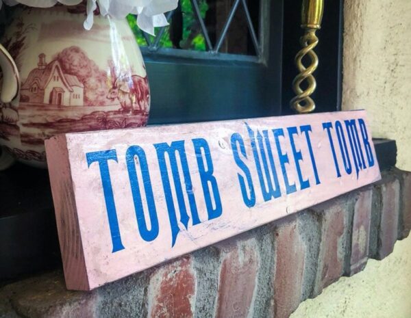 A sign that says " tomb sweet tombs ".