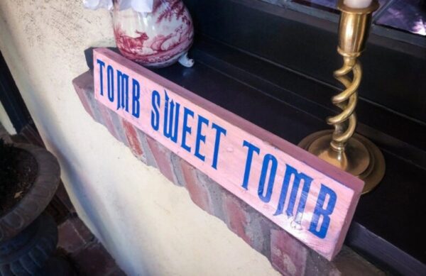 A sign that says " tomb sweet tomb ".