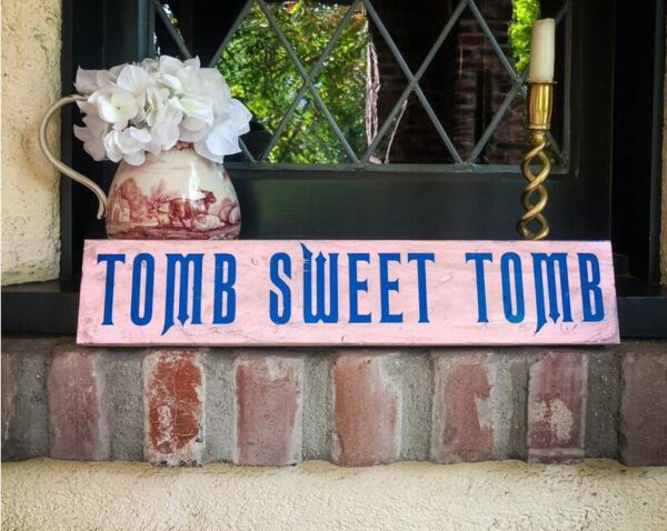 A sign that says " tomb sweet tomb ".