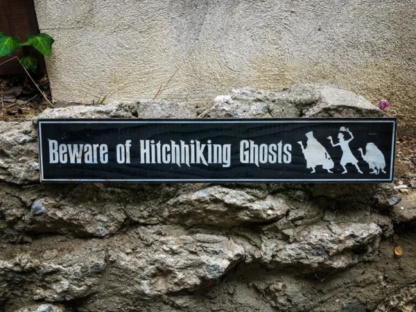 A sign that reads beware of hitchhiking ghosts.