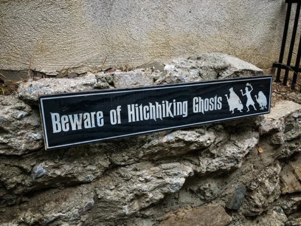 A sign that says beware of hitchhiking ghosts.