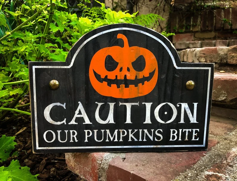 A sign that says caution our pumpkins bite.