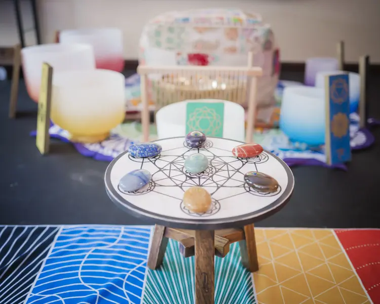 A table with seven different colored stones on it.