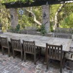 Long wooden patio table with chairs.