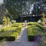 Formal garden with fountain and hedges.