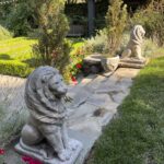 Stone lion statues in garden setting.