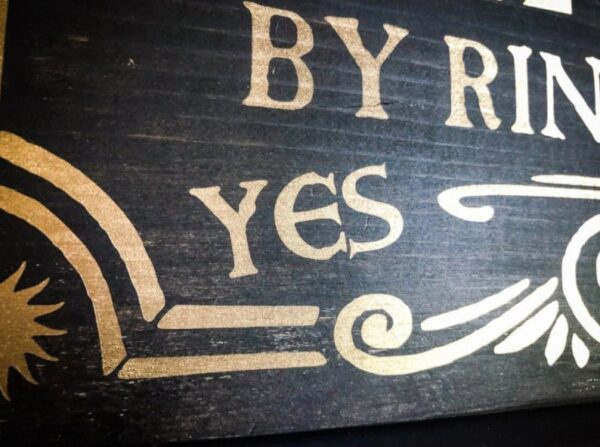 Black wooden sign: "By Ring, Yes"