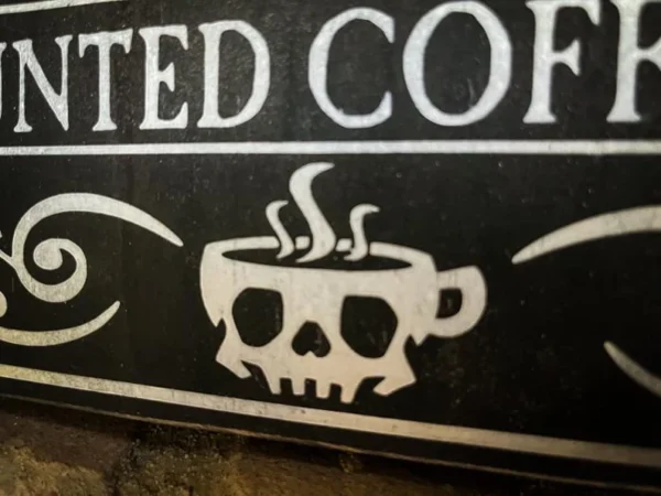 Haunted coffee skull mug sign.