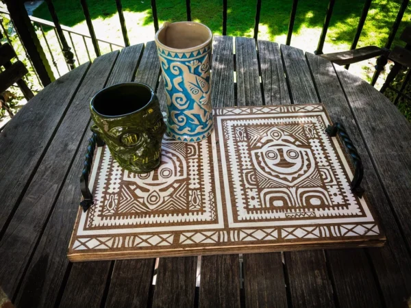 Tiki mugs and tray on wooden table.