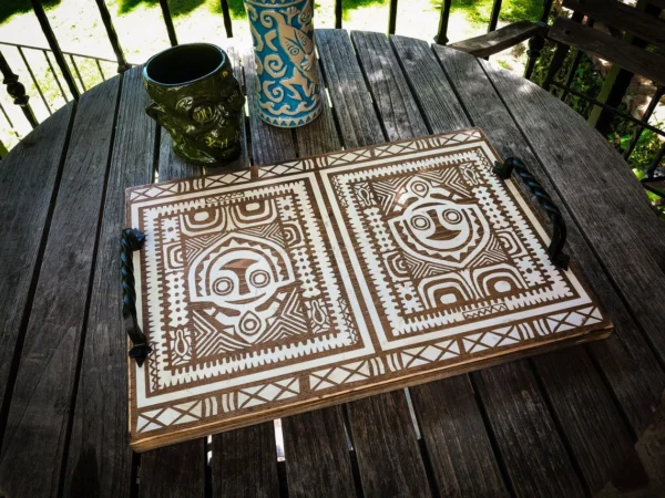 Wooden tray with tiki designs.