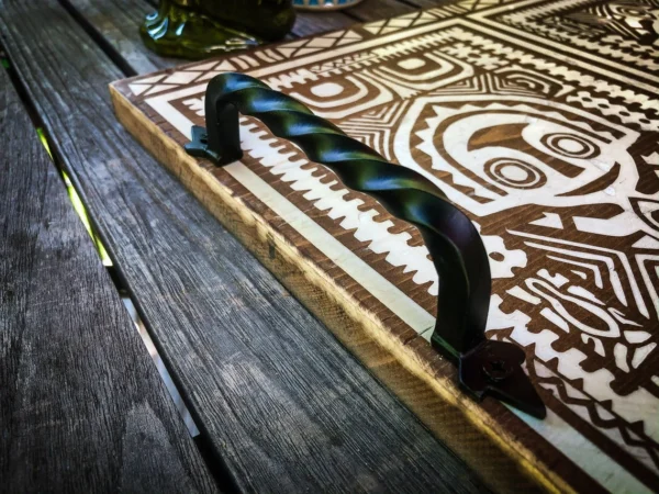 Wooden tray with tribal design and handle.