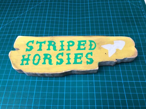 Hand-painted "Striped Horsies" wooden sign.