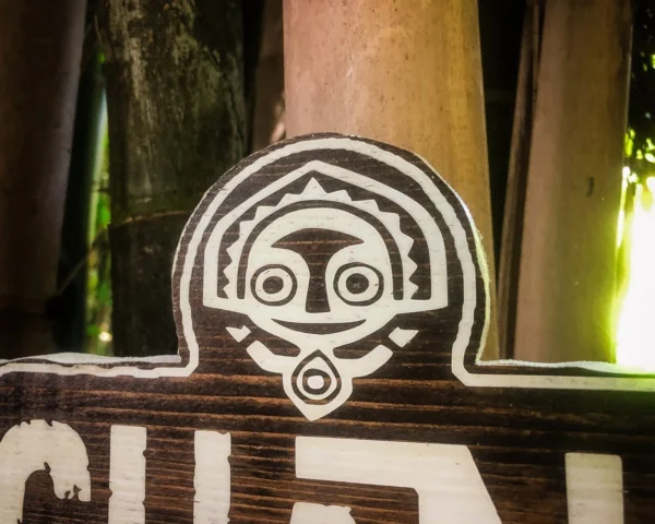 Wooden sign with Polynesian tiki face.