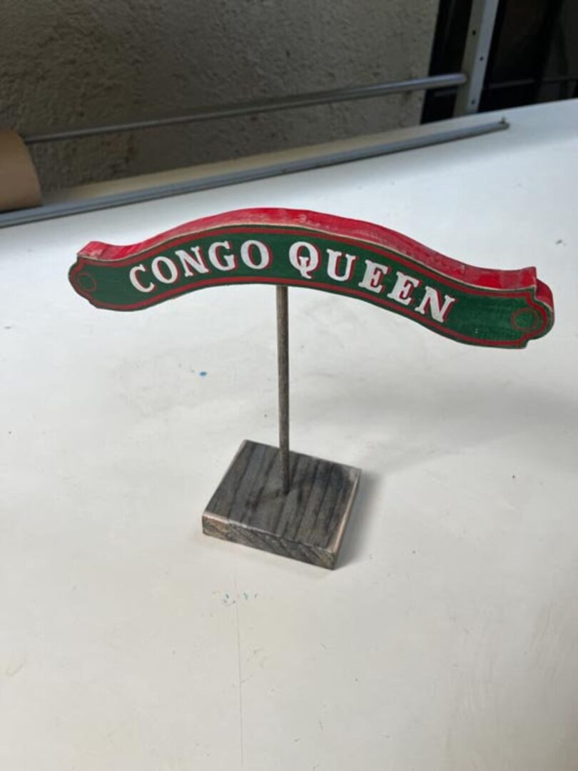 Here's an alt tag for the image: Congo Queen wooden sign.