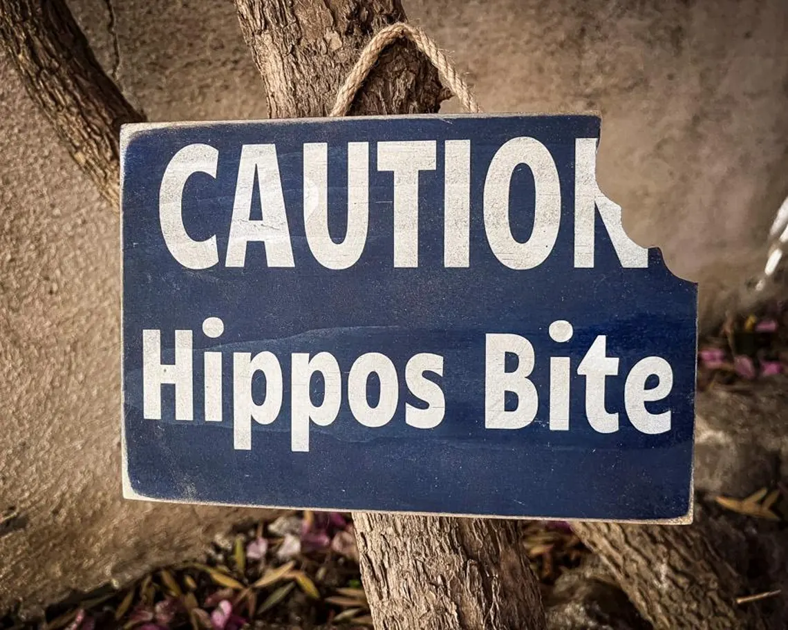 Caution: Hippos Bite - Damaged Sign.