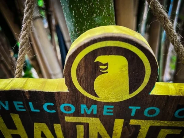 Wooden welcome sign with bird logo.