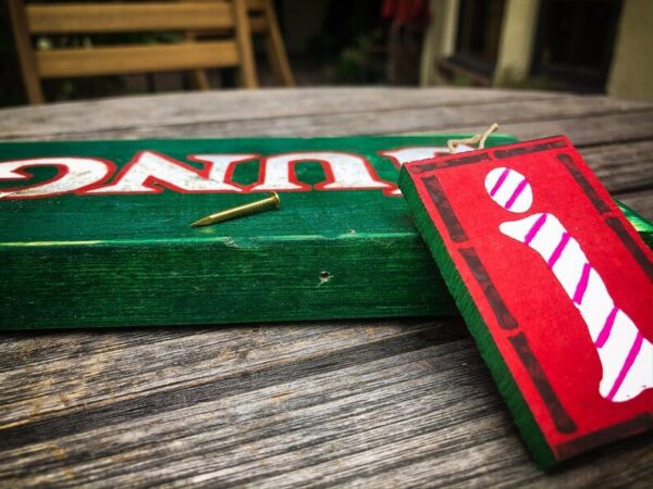 Green sign, red info block, brass nail.