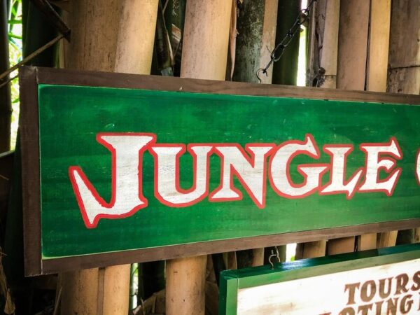 Green jungle sign with white letters.