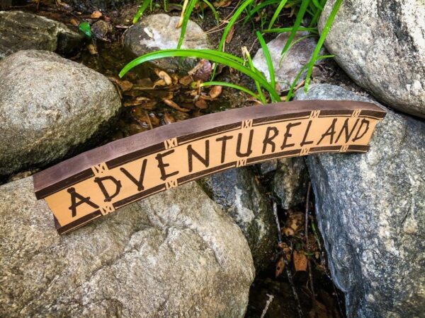 Adventureland sign on rocks.