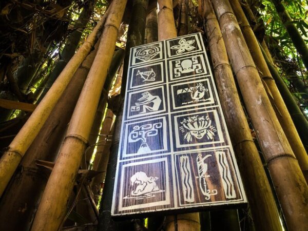 Wooden sign with carved symbols on bamboo.