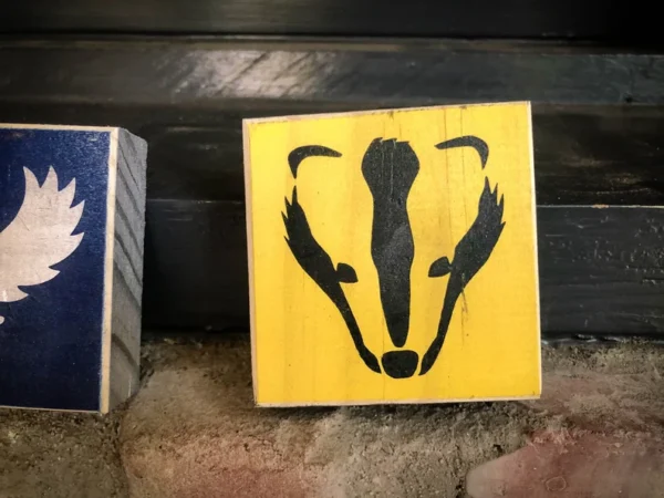 Yellow wooden block; badger silhouette.