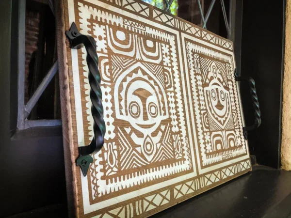 Wooden tray with tribal design and handles.