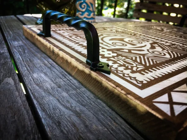 Wooden tray with ornate design and handle.