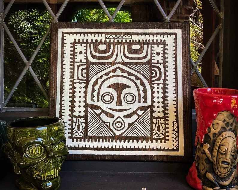 Wooden tiki mask art print with mugs.