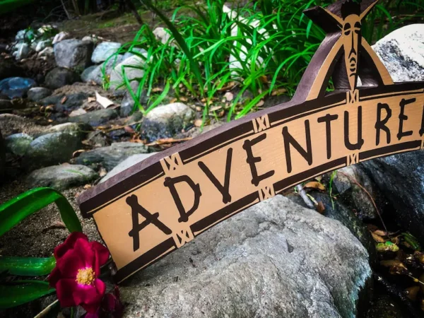 Wooden sign: Adventure awaits!