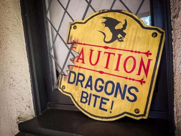 Caution: Dragons bite! Warning sign.