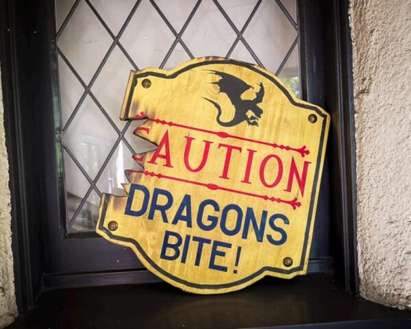 Caution: Dragons bite! Damaged sign.